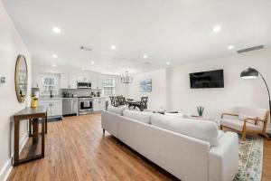 a living room with a white couch and a kitchen at Beautifully Modern Newly-Renovated Cottage in Norcross in Norcross +21 photos