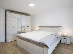 a white bedroom with a large bed and a dresser at Holiday Home in Medulin with Bubble Bath in Medulin
