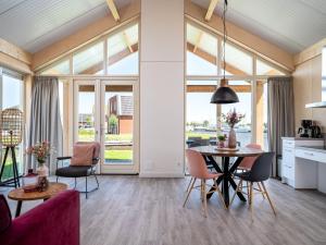 een keuken en een woonkamer met een tafel en stoelen bij Disabled house on the water, on a holiday park in Friesland in Akkrum