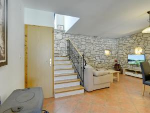 uma sala de estar com uma escada e uma parede de pedra em Boutique Holiday Home with Pool in egotici em Šegotići