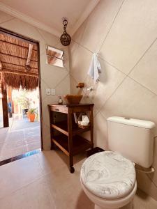 a bathroom with a toilet and a sink at Casa Mara Milagres in Passo de Camarajibe