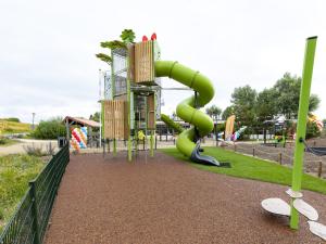 a playground with a green slide in a park at Bungalow in Netherlands with Garden Terrace in 's-Gravenzande