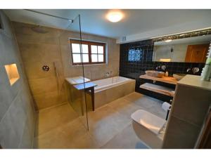 uma casa de banho com um chuveiro, uma banheira e um WC. em Beautiful wooden chalet with large garden and balcony, located in Barvaux em Barvaux