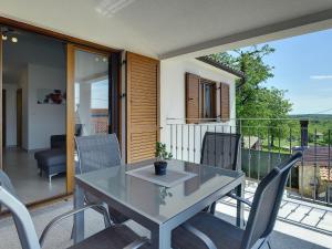 einen Tisch und Stühle auf dem Balkon eines Hauses in der Unterkunft Modern Holiday Home with Pool in Pazin in Lindar