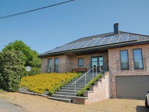 una casa de ladrillo con paneles solares en el techo en Modern Holiday Home in Noiseux with Garden, en Noiseux