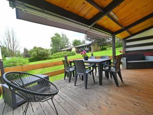 a patio with a table and chairs on a deck at Semi-detached bungalow for 6 people next to the Lac de Vallée de Rabais in Virton