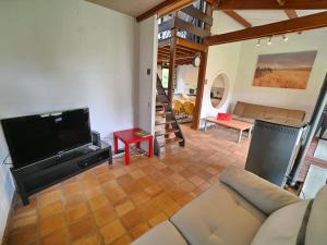 a living room with a couch and a flat screen tv at Semi-detached bungalow for 6 people next to the Lac de Vallée de Rabais in Virton