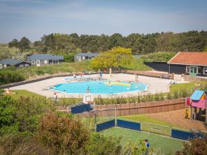 a large swimming pool in a park with people in it at Chalet on Texel with Private Sauna in Den Hoorn