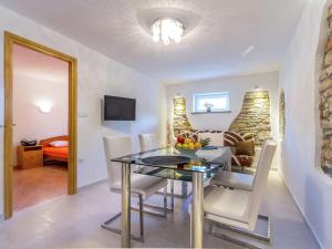 a dining room with a table and chairs and a couch at Apartment in Medulin near Sandy Beaches in Medulin
