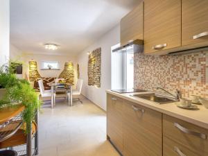 a kitchen with wooden cabinets and a dining room at Apartment in Medulin near Sandy Beaches in Medulin