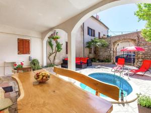 a house with a pool and a table with a bowl of fruit at Apartment in Medulin near Sandy Beaches in Medulin