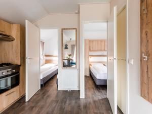 a small room with two beds and a kitchen at Covered Terrace Chalet at Leukermeer in Well +32 photos