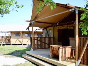 a wooden porch with awning on a house at Cozy Coastal Tent Stay in 's-Gravenzande