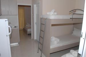 a small room with two bunk beds and a bathroom at Eleni Kandilari Rooms in Kokkino Nero