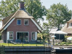een huis op het water met een boot erin bij Child-friendly villa, in a holiday park on the water in Friesland in Idskenhuizen