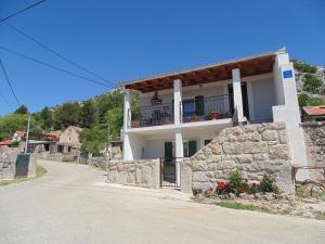 a white house with a balcony on a street at Holiday Home in Starigrad near Beach in Starigrad-Paklenica
