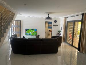 a living room with a couch and a tv at Villa Asya in Somone