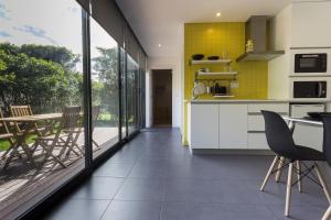a kitchen with yellow tiles and a table and chairs at Quinta das Rosas Villas in Ribeira Grande