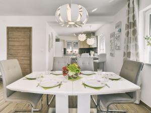 un comedor blanco con una mesa y sillas blancas en Modern Villa with Pool and Parasol in Pula en Pula