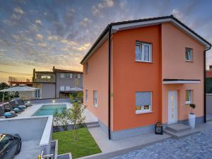 una casa naranja con piscina y patio trasero en Modern Villa with Pool and Parasol in Pula en Pula