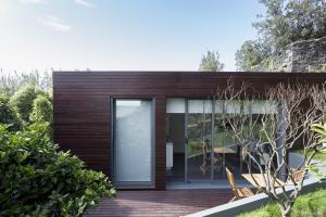 a house with a glass door on a deck at Quinta das Rosas Villas in Ribeira Grande