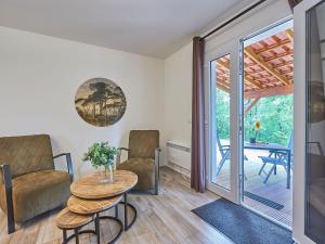 a living room with a table and chairs and a sliding glass door at Bungalow with a terrace on a hill in Dordogne in Mauroux