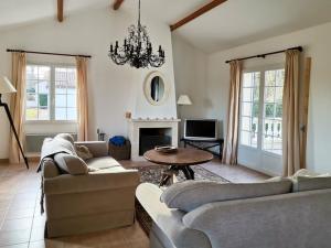 una sala de estar con 2 sofás y una lámpara de araña. en Detached villa with large garden near beautiful golf course, en Vasles