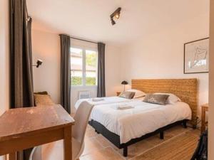 1 dormitorio con cama, mesa y ventana en Spacious and modern villa with large garden and BBQ area, en Les Forges
