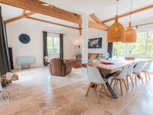 comedor y sala de estar con mesa y sillas en Spacious and modern villa with large garden and BBQ area en Les Forges