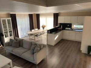 a living room and kitchen with a couch and a table at Holiday home in a holiday park directly on the recreational lake and the Veluwe in Lathum