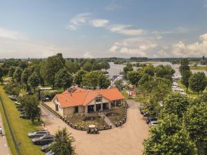 an aerial view of a house with a parking lot at Cozy tiny house on the water, located in a holiday park in the Betuwe in Maurik