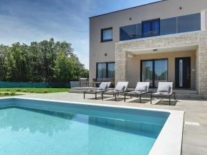a swimming pool in front of a house at Modern villa swimming pool , outdoor kitchen and fenced garden in Pula