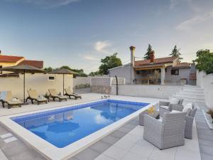 uma piscina com cadeiras e uma casa em Detached house with private pool, 15 minutes drive from the coast em Vodnjan