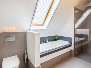 a bathroom with a bath tub and a window at Modern design lodge directly at the water, in national park in Tholen