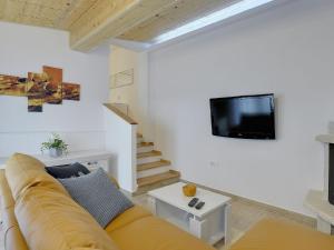 uma sala de estar com um sofá e uma televisão na parede em Detached house with private pool, 15 minutes drive from the coast em Vodnjan