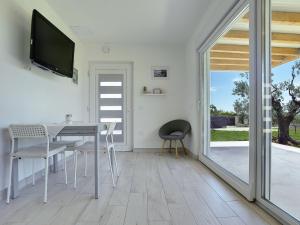 a dining room with a table and a television on a wall at Modern, detached holiday home with enclosed garden, near the centre and the beach in Fažana