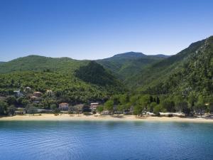 a view of a beach with mountains in the background at Modern chalet with two bathrooms, 9 km south of Opatija in Medveja