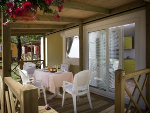 a dining room with a table and white chairs at Modern chalet with two bathrooms, 9 km south of Opatija in Medveja