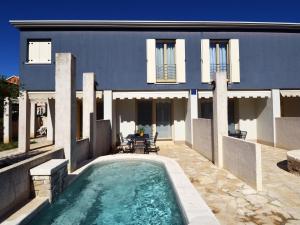 uma casa com piscina em frente a uma casa em Modern Villa Blue 1 with swimming pool ideal for families & friends em Banjole