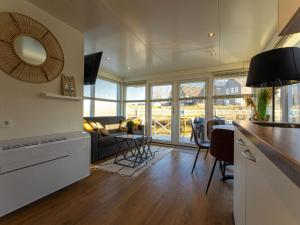 uma cozinha e sala de estar com um sofá e uma mesa em Lush houseboat with roof terrace in Lemmer em Lemmer