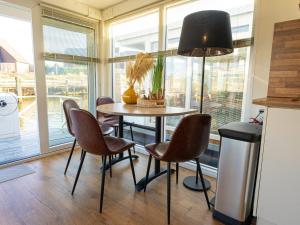 una mesa y sillas en una cocina con ventana en Lush houseboat with roof terrace in Lemmer, en Lemmer