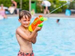 un jeune garçon jouant avec un jouet dans une piscine dans l'établissement Beautiful chalet with air conditioning in a holiday park on the Leukermeer, à Well