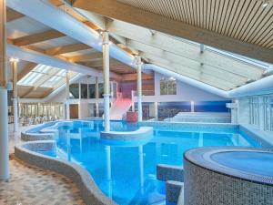 una gran piscina en un hotel con mesas y sillas en Modern chalet with dishwasher on Texel, en De Cocksdorp