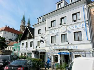 un hombre parado frente a un edificio en Hotel Anker, en Klosterneuburg