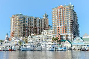 a group of boats docked in a marina with tall buildings at Emerald Grande W621 in Destin