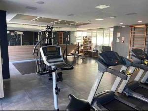 een fitnessruimte met loopbanden en crosstrainers in een kamer bij Encantador,Novo,Central,Com Garagem e Wifi 300Mbps in Pelotas