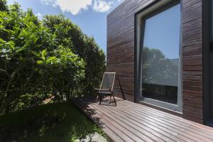 a chair sitting on the deck of a house at Quinta das Rosas Villas in Ribeira Grande