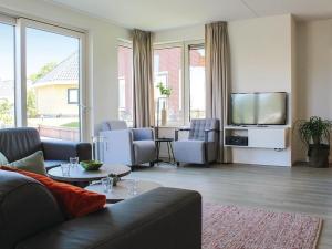 a living room with a couch and a flat screen tv at Villa in Friesland with Sauna and Jetty in Idskenhuizen