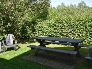 una mesa de picnic de madera y una silla en el césped en Nice g te with private garden in Br ly de Pesche, en Couvin