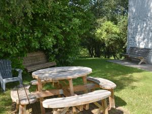 una mesa de picnic de madera y bancos en un parque en Nice g te with private garden in Br ly de Pesche, en Couvin